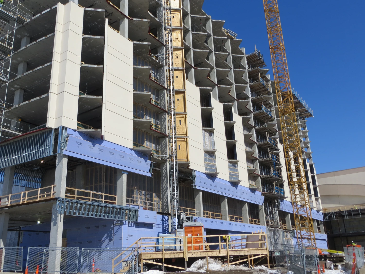 Building under construction with gray wall panels.
